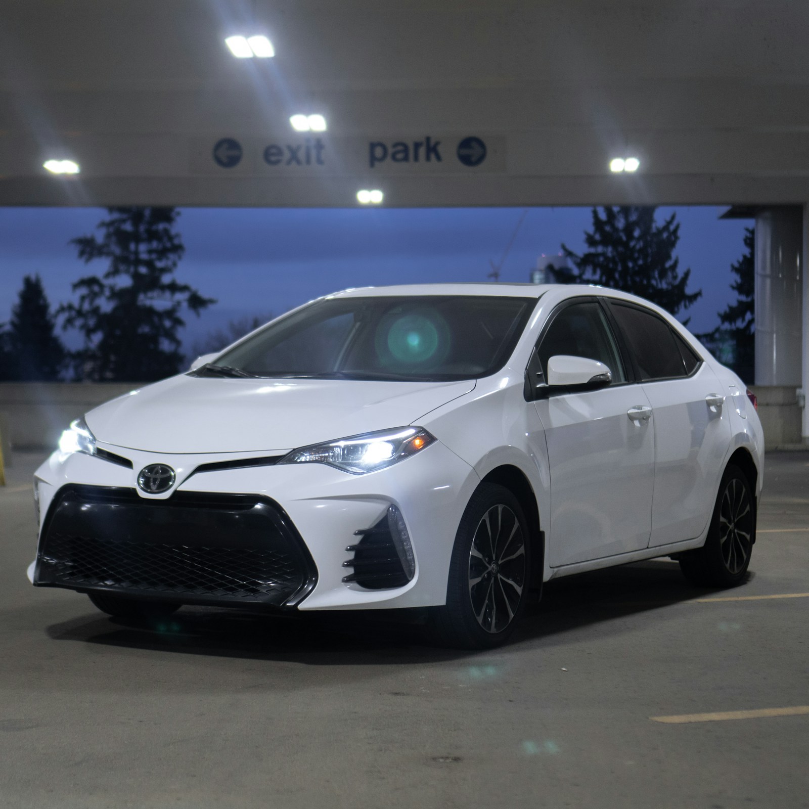 White sedan parked in a garage